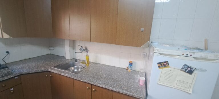 Kitchen sink, tiled backsplash and wooden cabinets in the Hakalir 4-bedroom apartment in Rechavia.