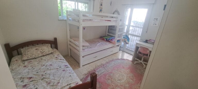 Bedroom with bunk beds, a single bed and a desk in the Hakalir 4-bedroom apartment in Rechavia.
