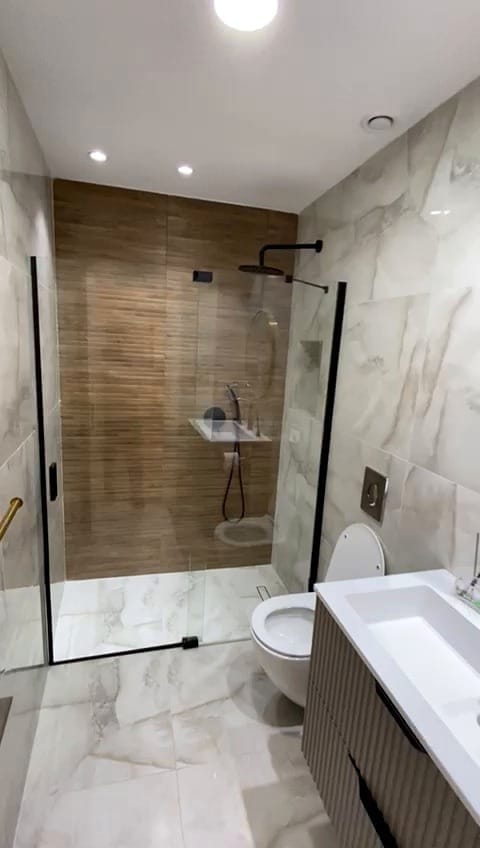 Modern full bathroom with walk-in shower in the KKL Shaarei Chessed 2 bedroom apartment