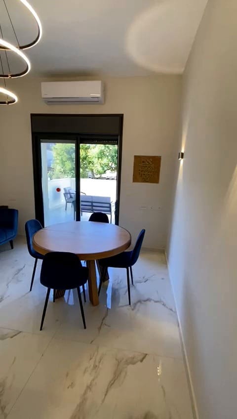 Living and dining area leading to private outdoor space in the 2 bedroom KKL Shaarei Chessed apartment