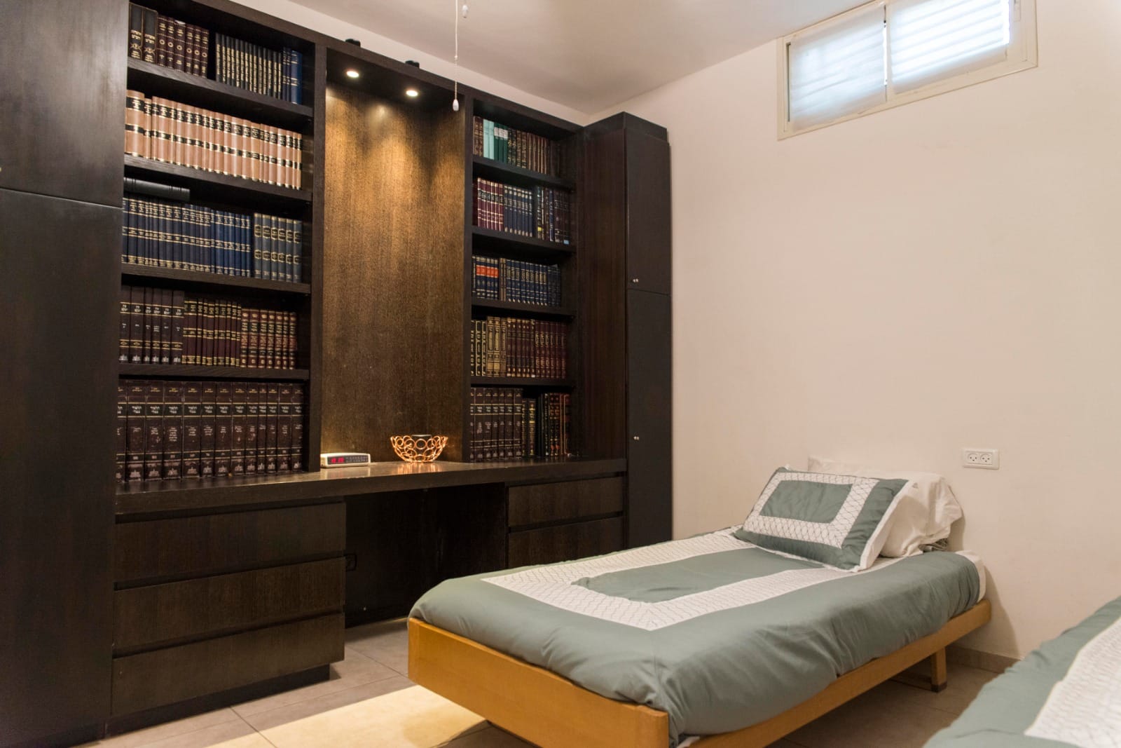 Bedroom with library in the Ramban Rechavia apartment