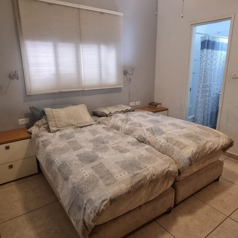Two individual beds with bedside cabinets in the main bedroom at Ramban Giant Sukkah Apartment, Jerusalem