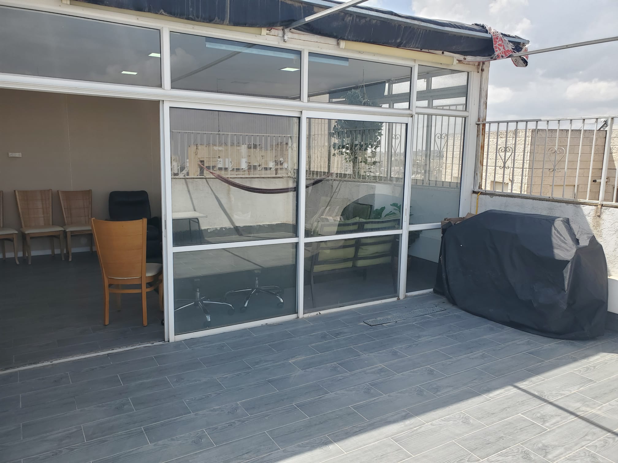 מרפסת פרטית והחלק החיצוני של חדר הגג הסגור בזכוכית