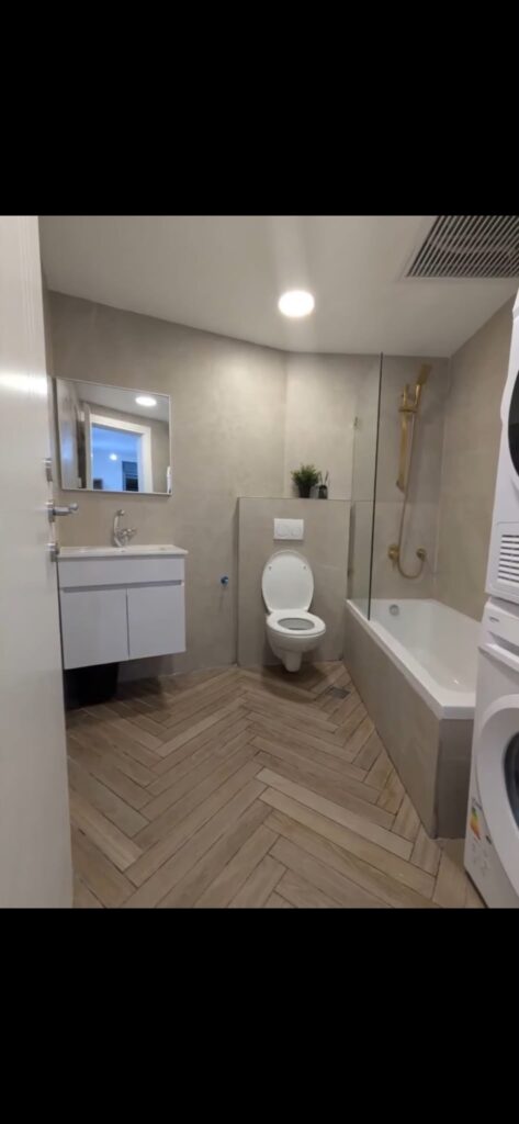 Bathroom with bathtub, washing machine and dryer at the Navon apartment in Mekor Baruch