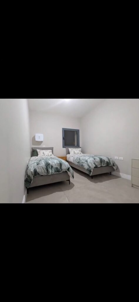 Bedroom with two separate single beds at the Navon apartment in Mekor Baruch