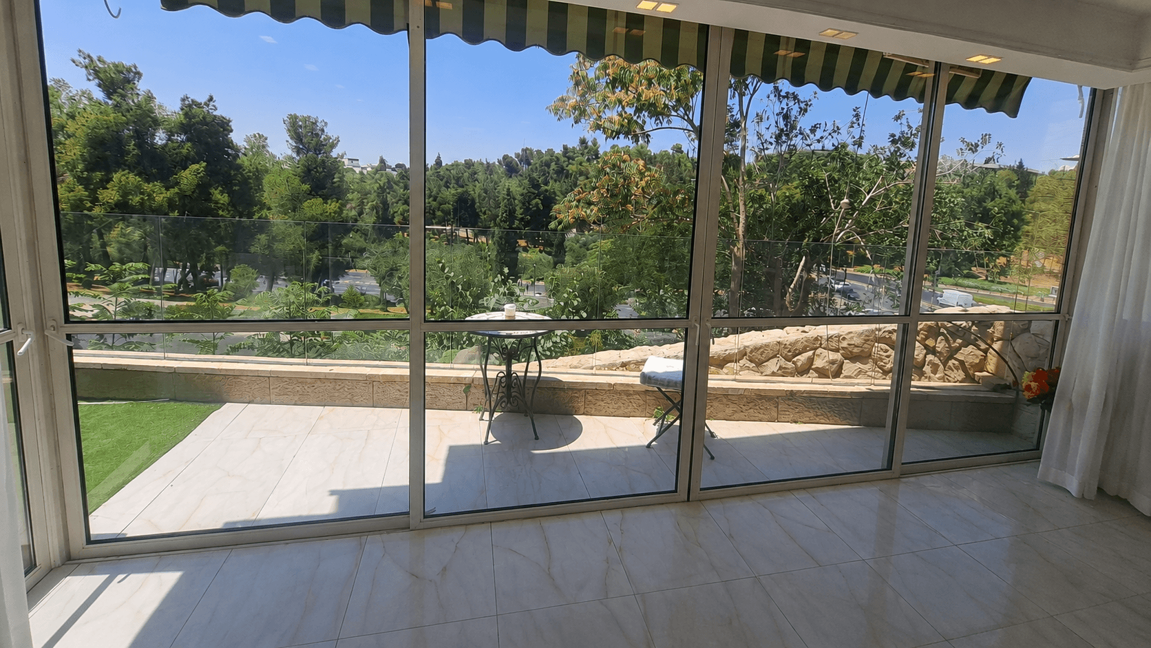 Reception and dining room opening toward the panoramic terrace and Gan Sacher at Wolfson Villa.
