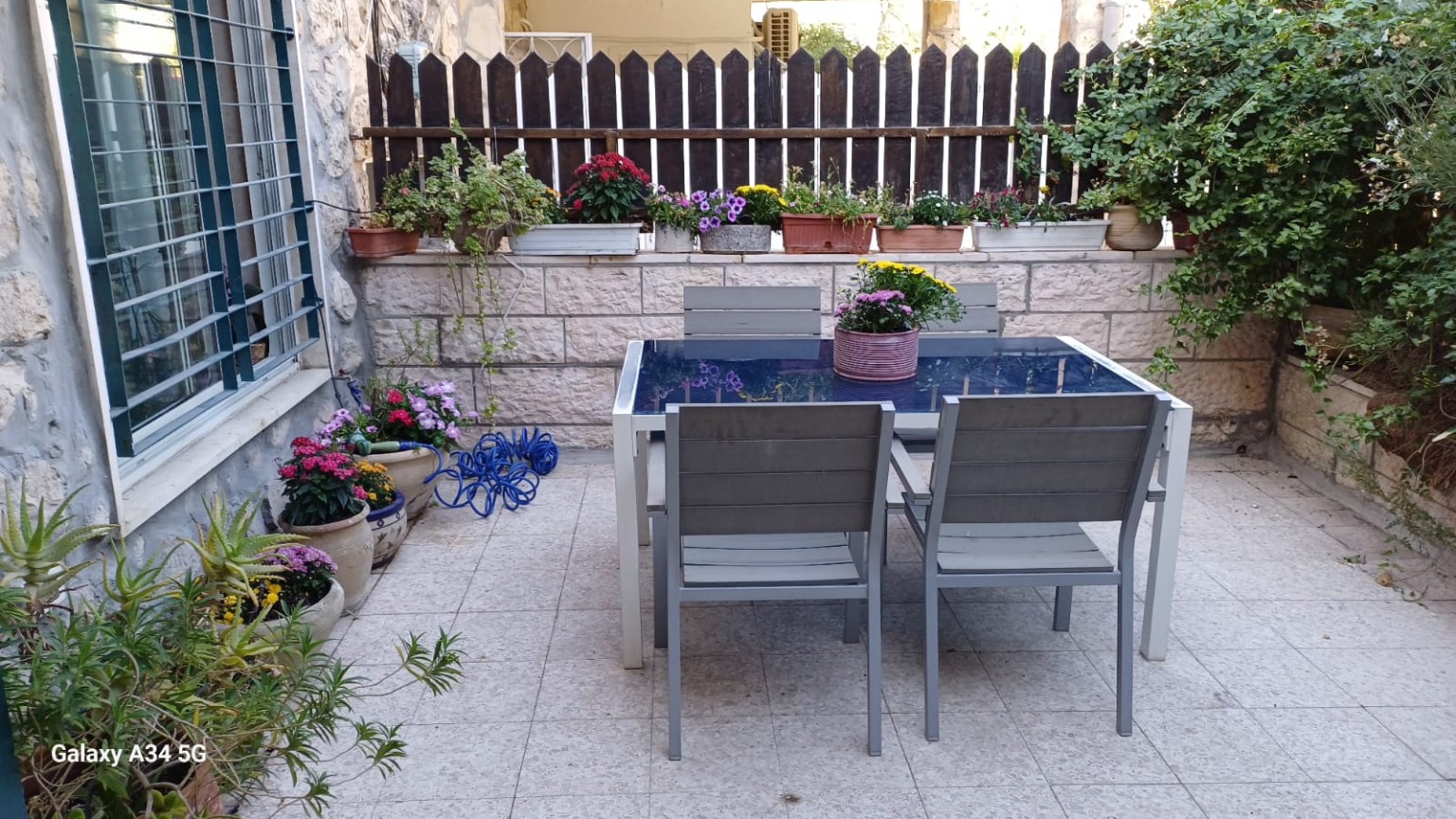 חצר פרטית וסגורה עם פינת אוכל, אבן ירושלמית וצמחייה