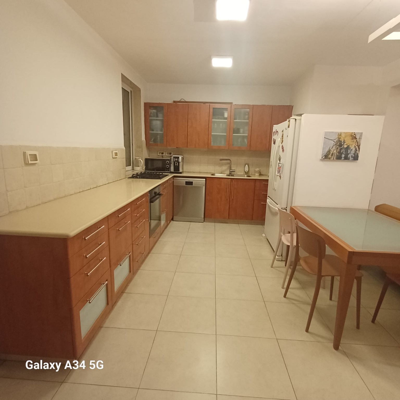 מטבח כשר גדול עם ארונות רבים, משטחי עבודה ארוכים ושולחן משפחתי