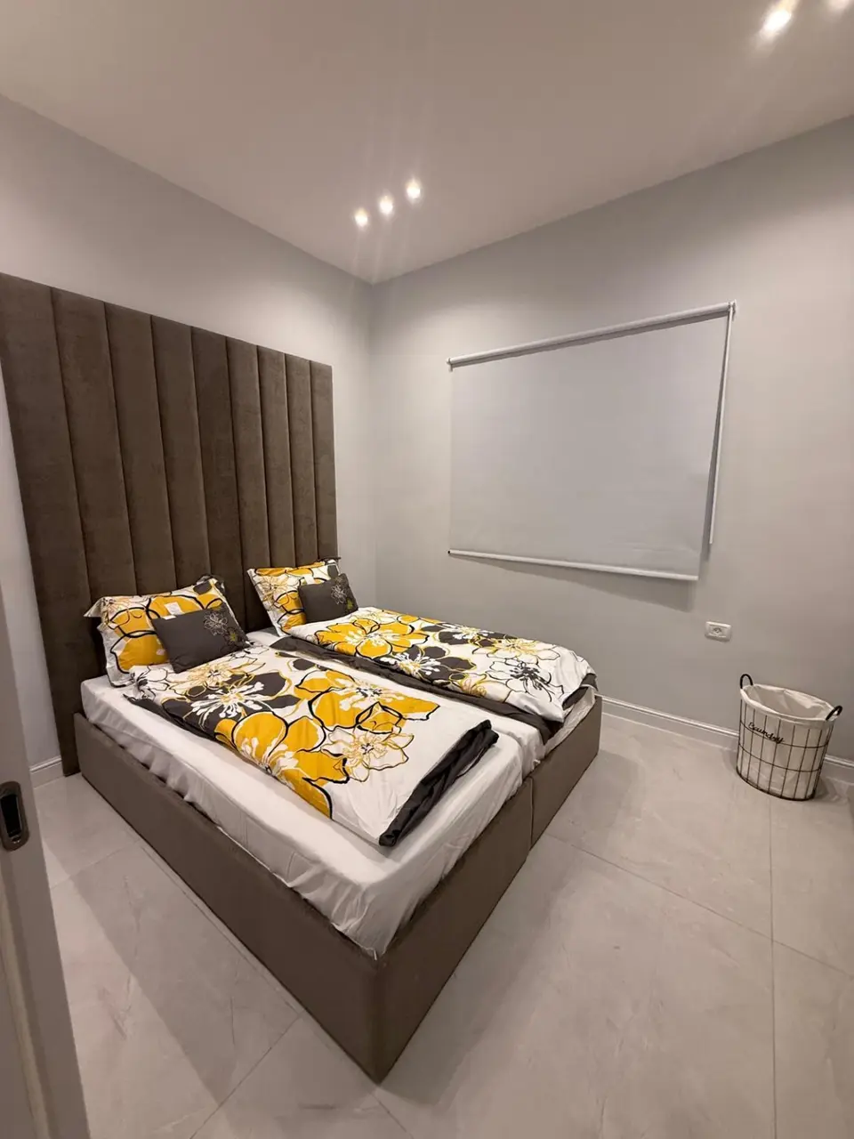 Twin bedroom with coordinated yellow floral bedding in the Ramban Rechavia four-bedroom apartment