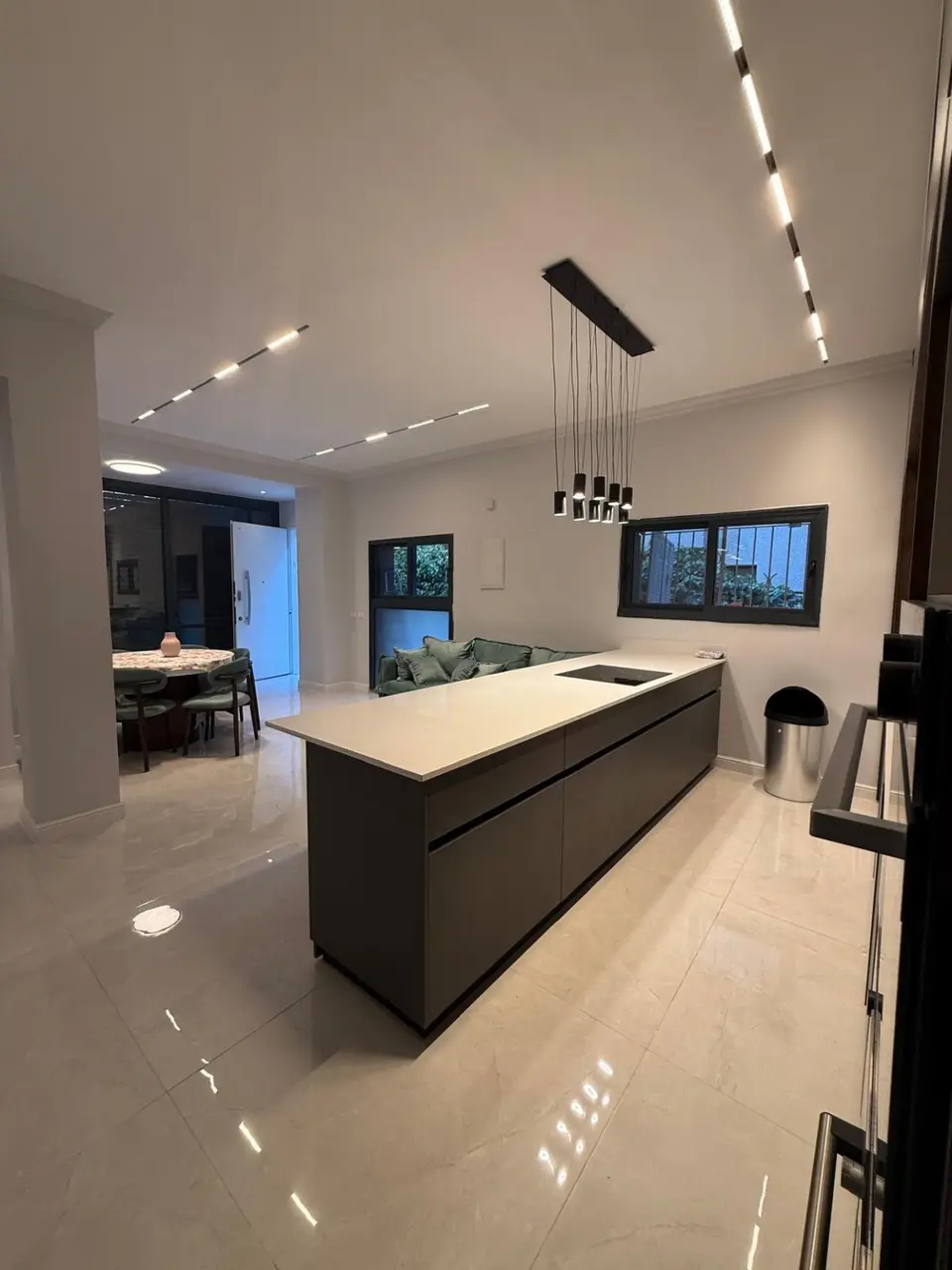 Open-plan kosher kitchen and dining area with a large island in the Ramban Rechavia apartment