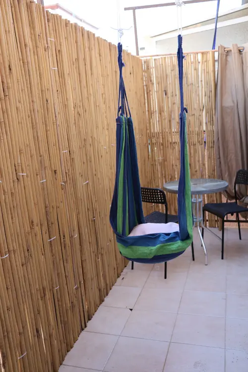 Private screened sukkah with hanging hammock chair in Beit Yisrael