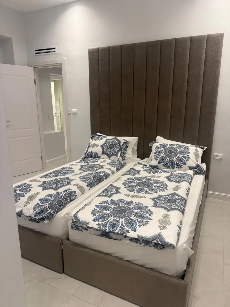 Twin bedroom with coordinated blue bedding in the Ramban Rechavia four-bedroom apartment