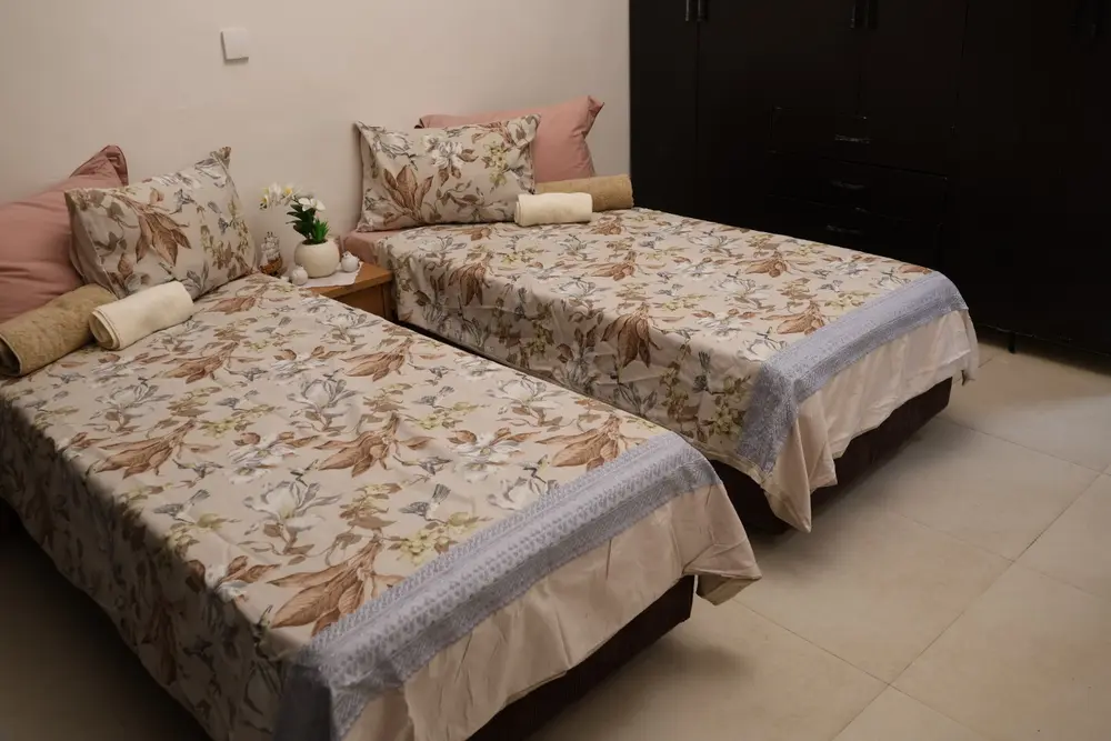 Second bedroom with two separate single beds and wardrobe in the Beit Yisrael apartment
