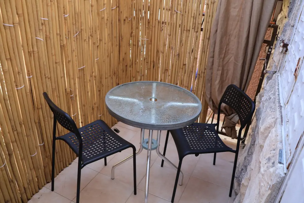 Private sukkah with table and chairs at the Yochanan Mizrachi Street apartment