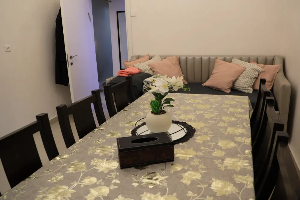 Large dining table and upholstered daybed in the Yochanan Mizrachi Beit Yisrael apartment