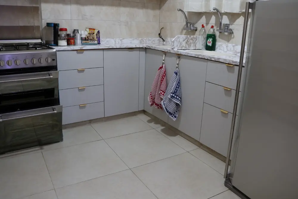 Separate L-shaped kitchen with refrigerator, gas range, oven and multiple sink areas